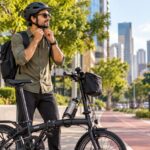 Ciclista urbano ajustando o capacete ao lado de uma bicicleta dobrável antes de pedalar pela cidade.